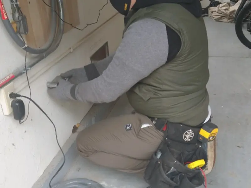 Electrician performing outlet wiring in a Emerson garage